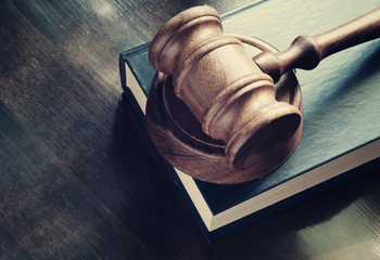 Judge gavel and legal book on wooden table