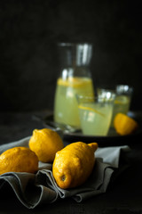 Trendy ugly organic lemons unusual shape for lemonade on dark background.Ways to turn ugly fruits into attractive and healthy dishes to reduce food waste.Imperfect products.Vertical orientation