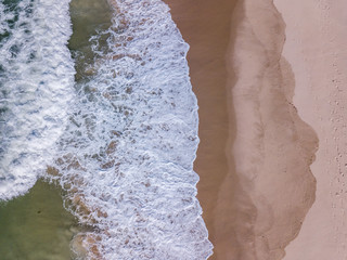 Drone picture of waves hitting the beach.