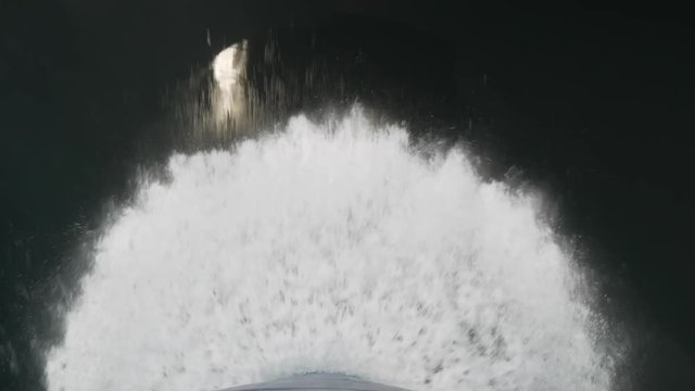 Bulbous bow of a high speed passenger ferry breaking water. Flat sea. Sea splashes.