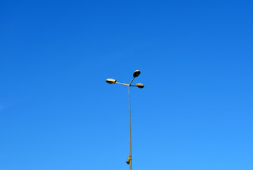 Street light with halogen lamp against blue sky
