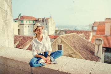 Fototapeta na wymiar Traveling by Croatia. Young traveling woman enjoying old town Split view, red tiled roofs and ancient architecture.