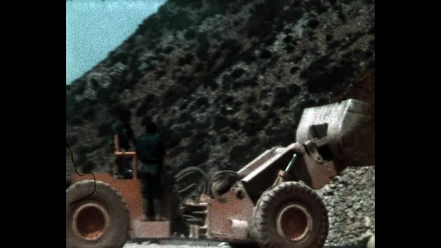 1970s, Italy: Miner working outside a mine with tractor