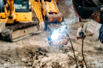 close up of welding details, sparks on construction site excavator