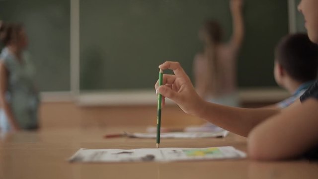 Schoolboy rise hand in classroom. Elementary school. Education