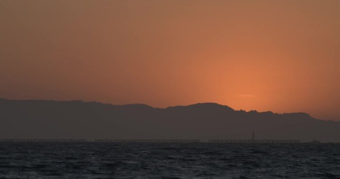 Sailboat sailing after sunset in San Francisco Bay Area in summer