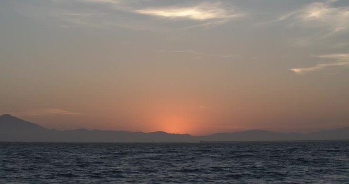 Sunset in San Francisco Bay area from Berkeley waterfront with waves and sun rays