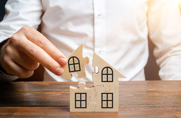 A man collects a house of puzzles. Construction of your own residential building. Mortgage loan,...