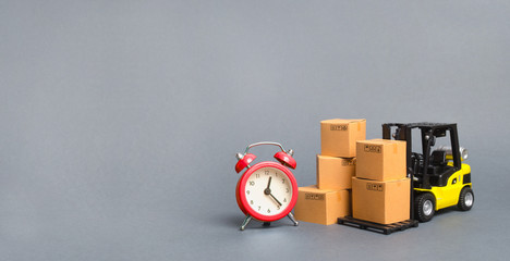 Obraz premium Yellow Forklift truck with cardboard boxes and a red alarm clock. Express delivery concept. Temporary storage, limited offer and discount. Optimization of delivery logistics. Banner, copy space
