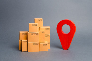 Lots of cardboard boxes and a red position pin. Locating packages and goods. Tracking parcels by...