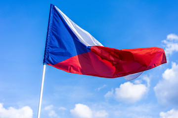 Fototapeta na wymiar The national flag of Czech republic. National flag of Czechia. Close up shot of a flag on a blue sky background. Czech flag waving in the wind.