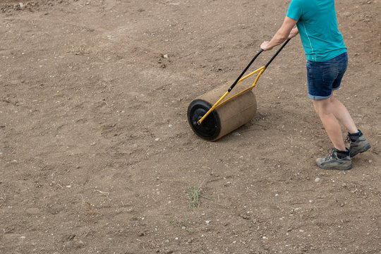 A woman with a soil roller at work