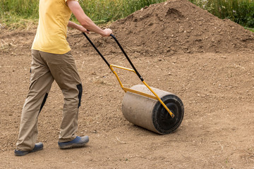 A man with a soil roller at work