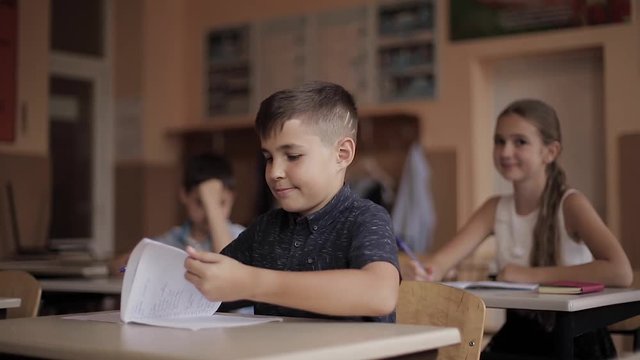 Boy and girl sitting at desk and writing a text