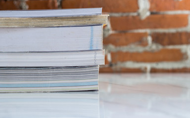 Stack of hardcover books on table against marble background, space for text