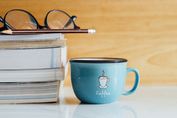 Open notebook and black coffee on white marble background.  Copy space