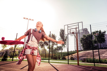Cheerful long-haired lady in summer outfit rolling around