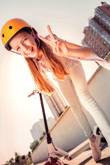 Positive young lady in yellow protective helmet exposing her feeling