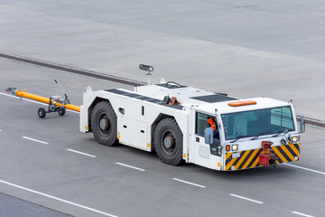 Aerodrome tow tractor is driving along the steering paths at the airport.