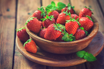 Fresh sweet strawberries on wooden bowl