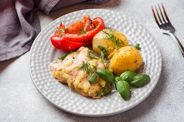 Baked potatoes with chicken and vegetables on a plate.