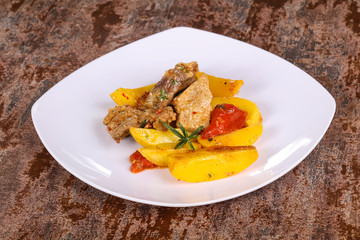 Baked pork meat with potao and tomato