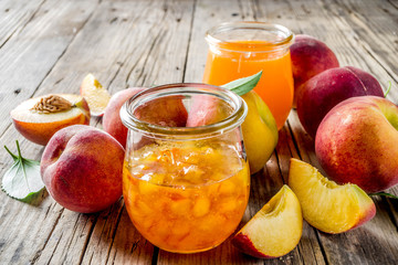 Homemade peach jam, with fresh organic peaches, rustic wooden background copy space