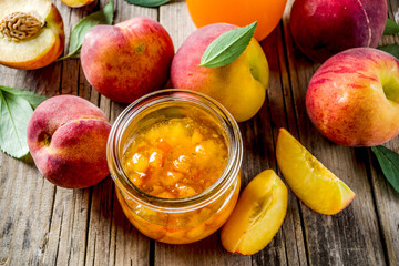 Homemade peach jam, with fresh organic peaches, rustic wooden background copy space