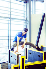 Fototapeta na wymiar young handsome man doing parkour in gym inside, lifestyle sport people concept