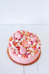 Pink cake. Decoration from sweets, macarons, marshmallows, white chocolate. Sweet birthday present. For girl.