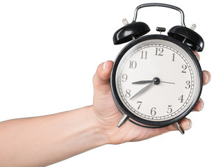 Woman's hand Holding an alarm clock isolated