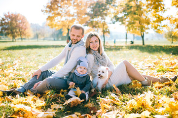 Happy family with their baby outdoor portrait in autumn park.