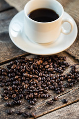 Coffee cup and coffee beans on wooden background. Top view