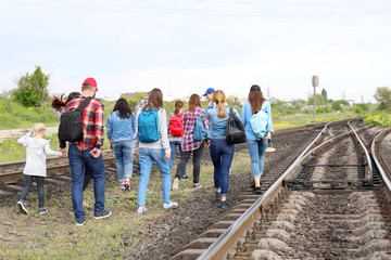 Group of illegal migrants walking along railway tracks