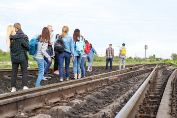 Group of illegal migrants walking along railway tracks