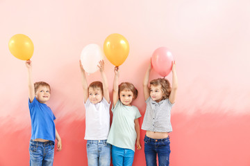 Cute little children with air balloons on color background