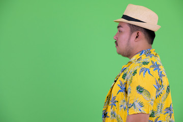 Profile view of young overweight Asian tourist man