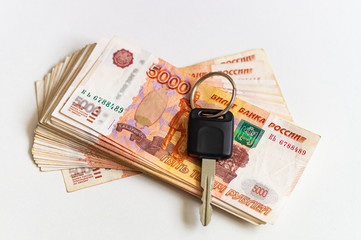 A set of five thousand banknotes and a car key, close-up. Savings on a new car. Buying a car in Russia.