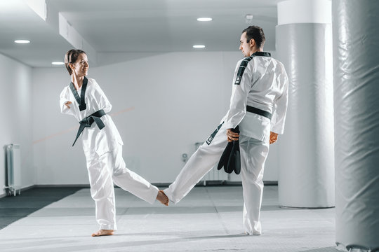 Young beautiful highly motivated armless Caucasian girl greeting with leg with her trainer.