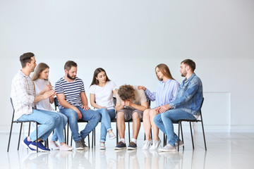 Young people calming man at group therapy session