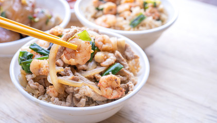 Braised shrimp over rice - Taiwan famous traditional street food. Soy-stewed prawn and sliced pork on cooked rice. Travel concept, copy space, close up