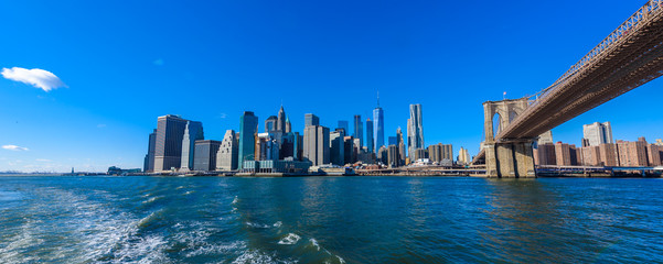 Fototapeta na wymiar Famous Skyline of downtown New York City, Brooklin Bridge and Manhattan with skyscrapers illuminated over East River panorama. New York, USA