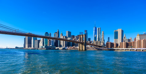 Famous Skyline of downtown New York City, Brooklin Bridge and Manhattan with skyscrapers illuminated over East River panorama. New York, USA