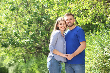 Fototapeta premium Happy young couple holding hands outdoors in park, smiling together, romantic relationship and summer lifestyle
