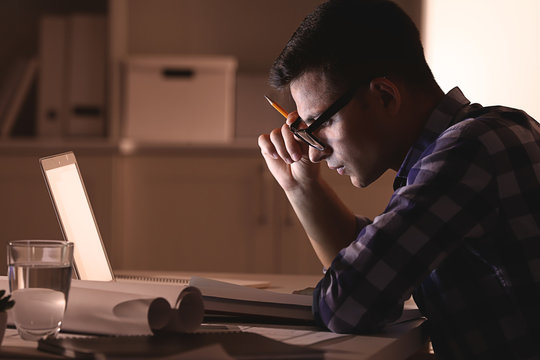 Busy Young Man Working At Home Late In Evening