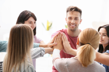 People putting hands together at group therapy session