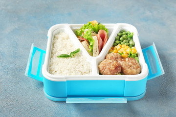 School lunch box with tasty food on color background