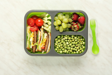 School lunch box with tasty food on light background