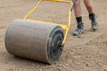 A man with a soil roller at work