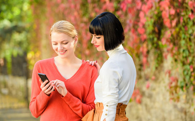 Fototapeta premium new technology. buy online on cyber monday. black friday online shopping. share info. social net. just look at this. 3g & 4g mobile internet surfing. two happy women look in phone. virtual worl